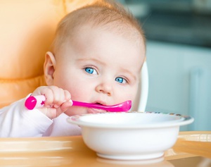 Годовалый ребенок ест с ложки